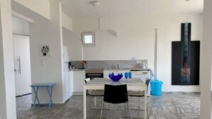 Une cuisine compacte avec un coin repas, une petite table et des chaises.