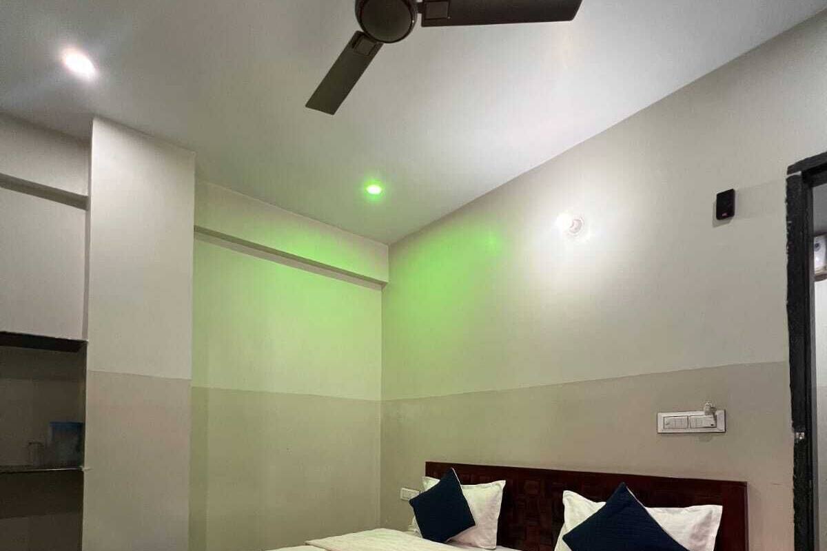 A bedroom with a bed, a ceiling fan, and a wall-mounted air conditioning unit.