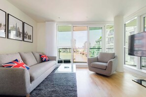 Ein modernes Wohnzimmer mit einer Couch, einem Sessel und einem Fernseher.