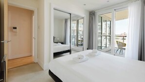 Ein Hotelzimmer mit Bett, Badezimmer und einem Balkon mit Stuhl.