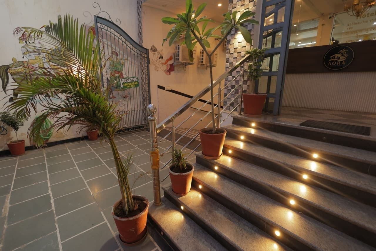 Una escalera con plantas en macetas y un cartel que indica un estacionamiento.
