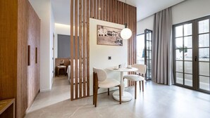 Ein modernes Hotelzimmer mit Essbereich, großem Fenster und einer Holzwand.