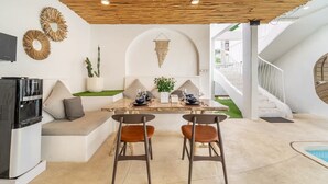 Una cocina moderna con refrigerador incorporado y comedor con mesa para dos.