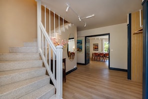A staircase with a white railing, a dining area with wooden flooring, and a hallway leading to another room. - 🏡 Renovated family villa with swimming pool, private garden, lake view & view of Menthon Castle and the surrounding mountains 🏔️ (Menthon-Saint-Bernard)