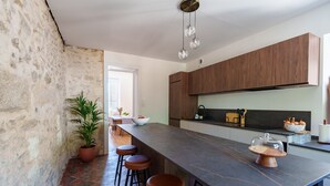 A modern kitchen with a large island, bar stools, wooden cabinets, and a potted plant. - Entire Villa: Eyrans, France – 10 Guests, 5 Bedrooms, 5 Beds, 4 Bathrooms (Eyrans)