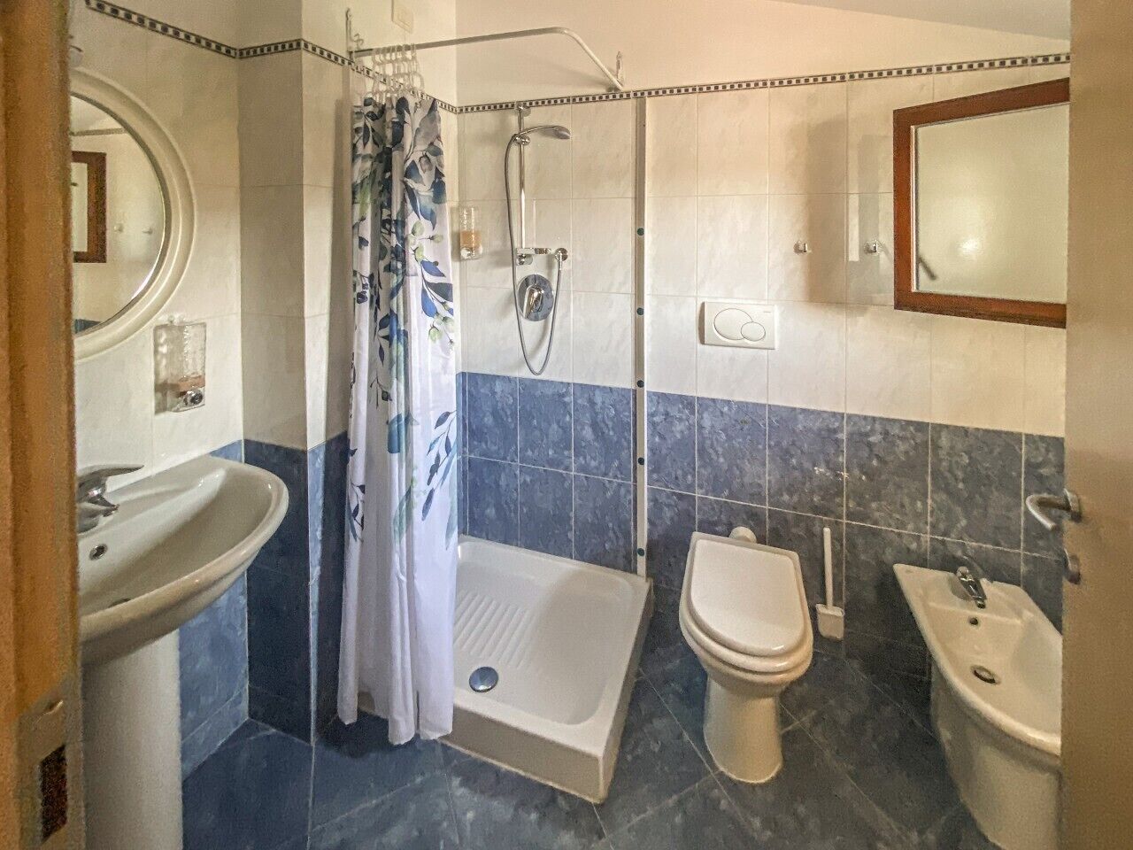 Un baño con ducha, inodoro, bidé y lavabo.