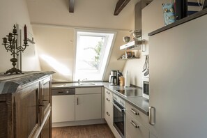 Eine Küche mit Fenster, Kaffeemaschine und Herd.