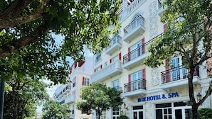 Een hotel met een spa, terras en een geplaveid straatje.