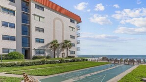 Um hotel com área de piscina, área de estar externa e vista para o mar.