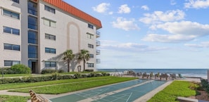 Ein Hotel mit Poolbereich, Sitzgelegenheiten im Freien und Blick aufs Meer.