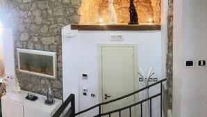 A stone wall, a white door, a framed picture, and a staircase railing.