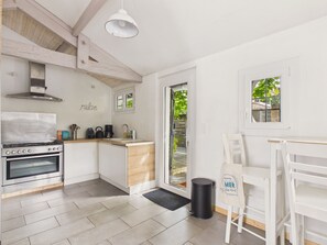 A compact kitchen with a stove, coffee maker, and a small sink. - 250 m from the lake, house for 6 adults / 2 children (Andernos-les-Bains)