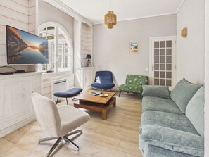 A living room with a television, a sofa, a chair, a coffee table, and a door. - 250 m from the lake, house for 6 adults / 2 children (Andernos-les-Bains)