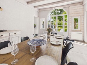 A dining area with a wooden table, chairs, and a white cabinet. - 250 m from the lake, house for 6 adults / 2 children (Andernos-les-Bains)
