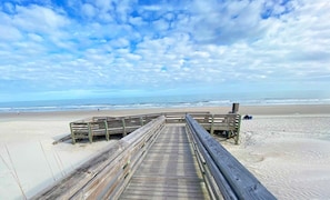 A wooden boardwalk leading to a beach with a clear sky. - Retreat 511 with Ocean View & 2 Covered Parking Spots! (Pawleys Island)