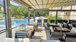 A rooftop terrace with a pool, seating areas, and a view of the surrounding greenery. - Status M Apartments 151 (Becici)