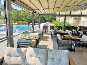 A rooftop terrace with a pool, seating areas, and a view of the surrounding greenery. - Status M Apartments 151 (Becici)