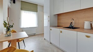 A modern kitchen with white cabinets, a wooden countertop, and a built-in sink. - Sea & Monte City Center Apartments Sopot (Sopot)