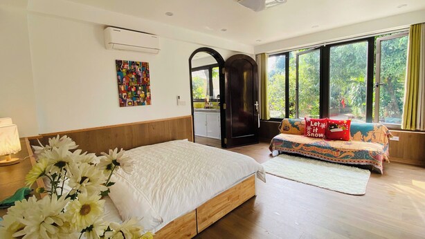 Ein Schlafzimmer mit einem Bett, einer Couch, einem Fenster und einer Klimaanlage.