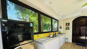 Eine Küche mit Kühlschrank, Spüle und einem Fenster mit Blick auf Bäume.