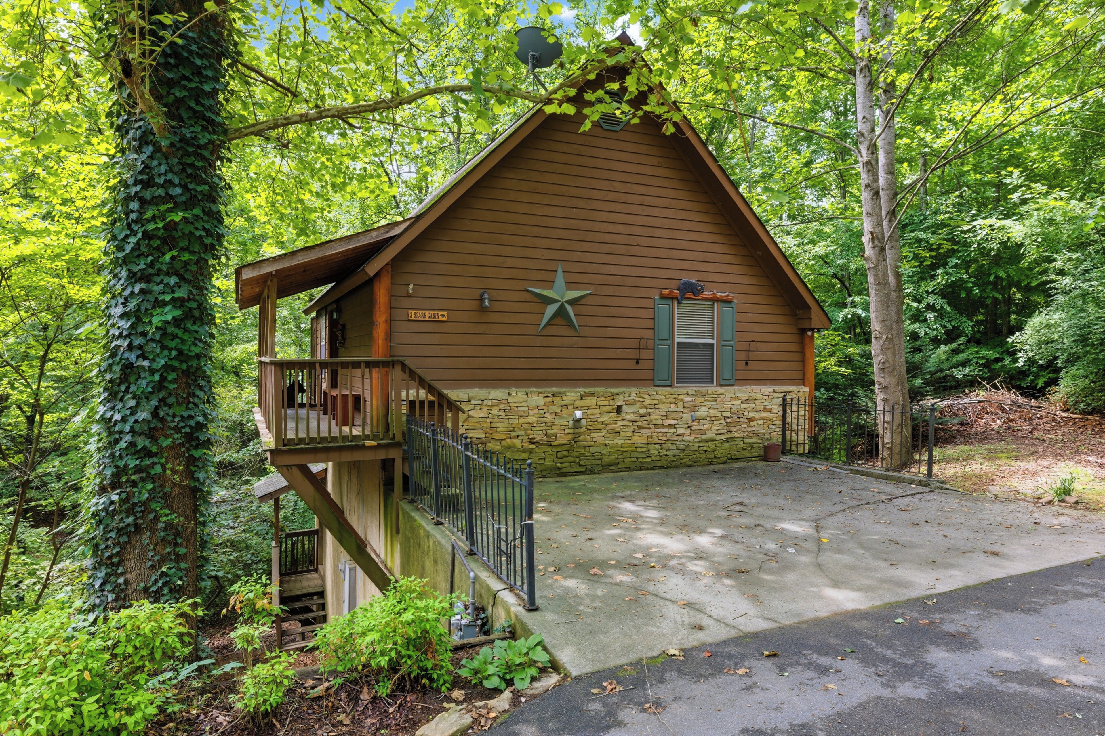 A cabin with a stone foundation, a wooden deck, and a star decoration on the wall.