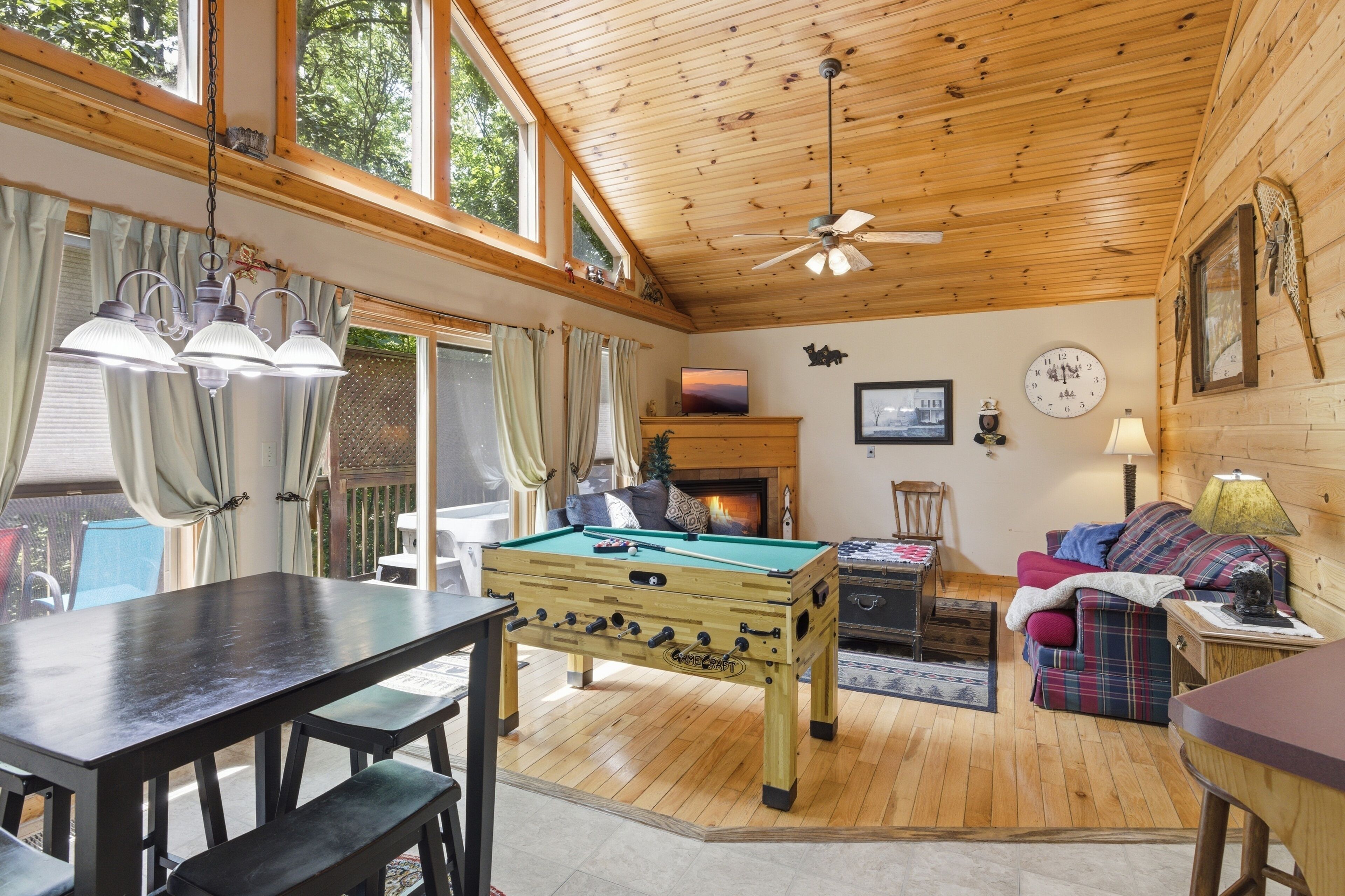 A cozy indoor space with a pool table, a sofa, and a fireplace.