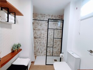 Ein Badezimmer mit Dusche, Toilette und Handtuchhalter.