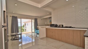 A modern kitchen with a wooden countertop, a microwave, and a gas stove. - Beautiful studio with AC in charming Anse Royale (Anse Royale)