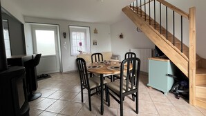 Ein Essbereich mit Holztisch und Stühlen, einer Treppe und einem Heizkörper.