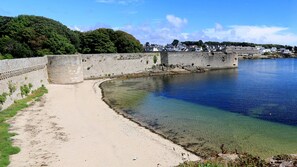 A coastal walkway with a clear view of the sea and a stone wall.