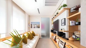 Een moderne woonkamer met een bank, een televisie en een boekenkast.
