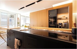 A modern kitchen with a large island, built-in oven, and a refrigerator. - Luxury designer apartment in the heart of Rome (Roma)