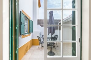 Ein Zimmer mit Fenster, Tür und einem Tisch mit Stühlen.