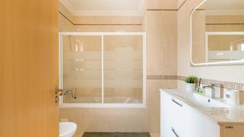 Ein Badezimmer mit einer Badewanne, einem Waschbecken, einem Spiegel und einem grünen Teppich.