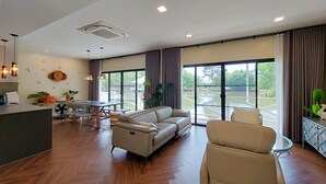 Uma sala ampla com sofá, mesa de jantar e cozinha.