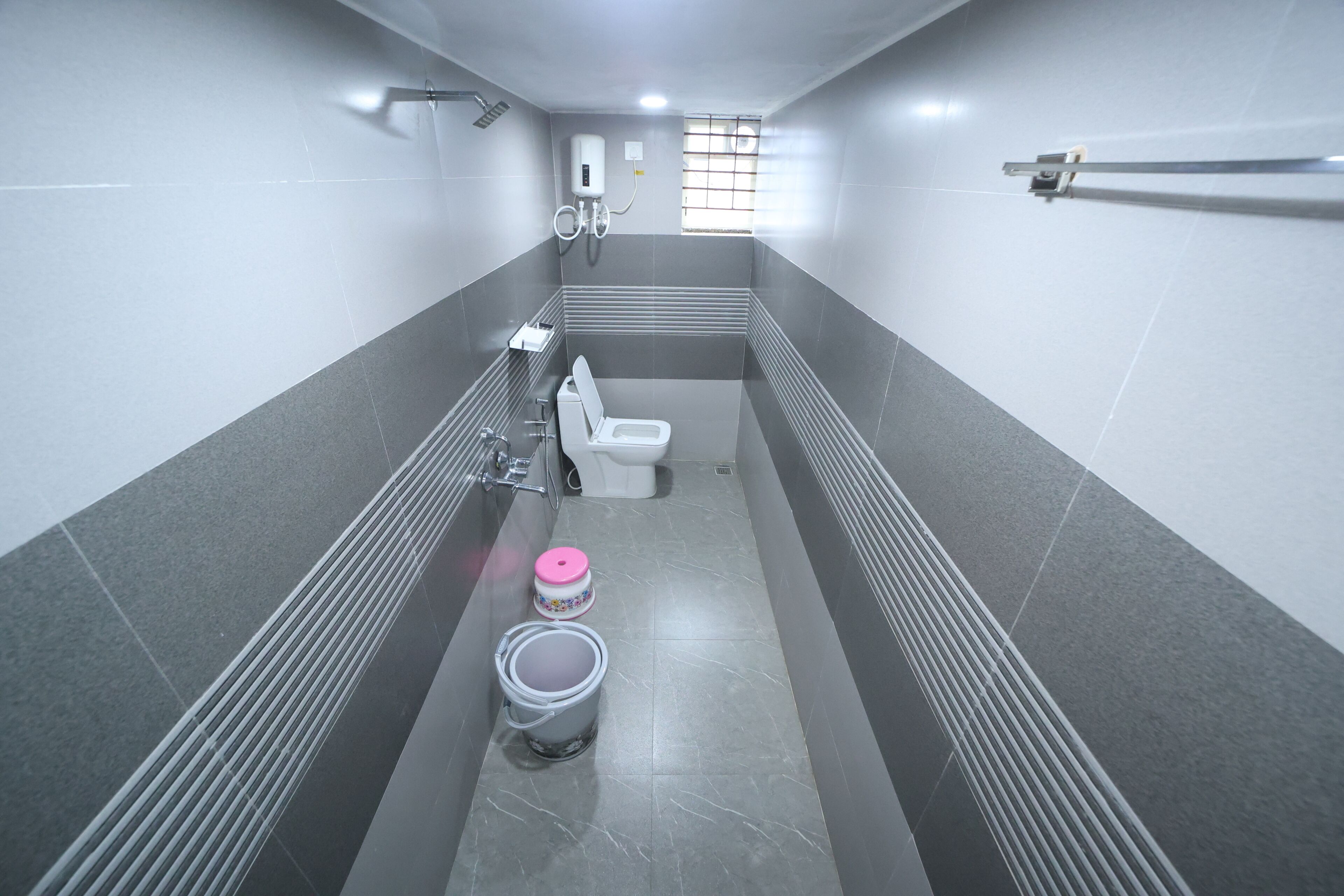 Une salle de bain moderne équipée de toilettes, d’un bidet et d’un seau.