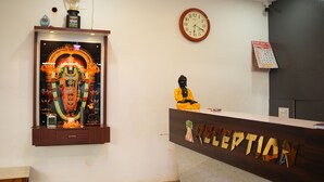 A reception desk with a clock and a calendar on the wall. - Aarna Coastal Resort (Bhatkal)