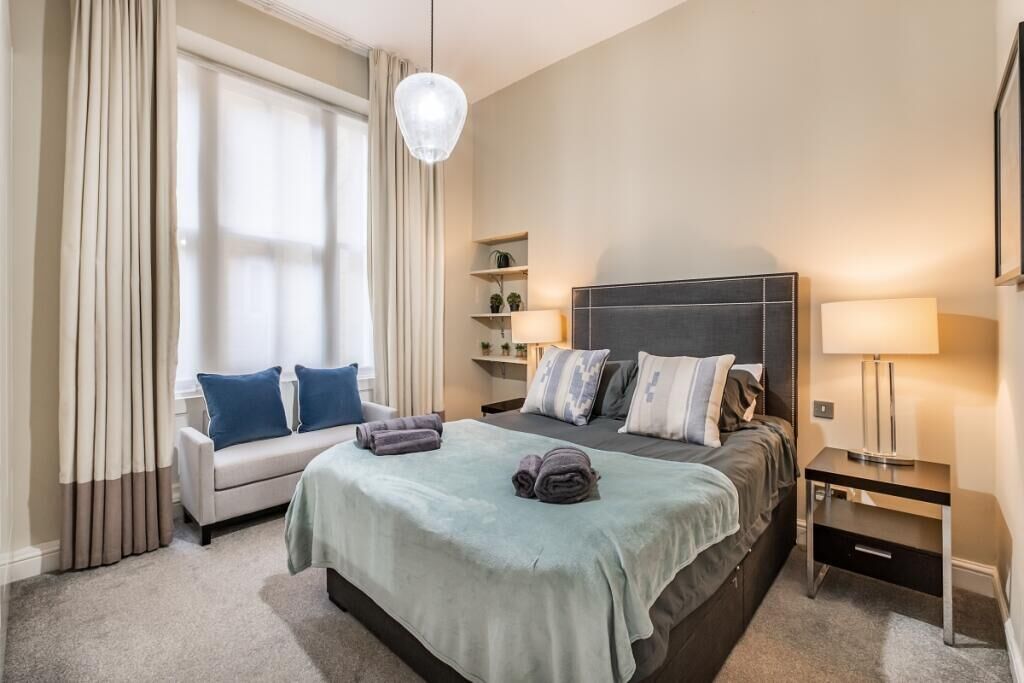 Ein Hotelzimmer mit Bett, Sofa, Schreibtisch und Lampe.
