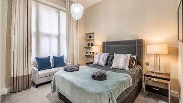 Ein Hotelzimmer mit Bett, Sofa, Schreibtisch und Lampe.