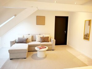 Ein modernes Wohnzimmer mit einer Couch, einem Couchtisch und einer Tür.