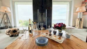 Une table en bois, avec une bouteille de champagne, des verres à vin et un plateau de pâtisseries.
