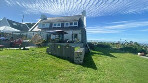 Un bâtiment doté d’un patio, d’un espace extérieur aménagé pour s’asseoir et offrant une vue sur la mer.