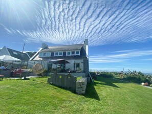 A building with a patio area, outdoor seating, and a view of the sea. - Beach house with 280-degree sea view in Kergoz (Landeda)