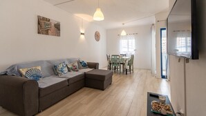 A modern living room with a sectional sofa, dining table, and chairs. - 2 bedroom apartment Praia Da Rocha (Portimão)