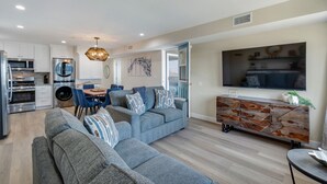 A modern living space with a kitchen, dining area, and seating area. - 3BD/3BA | Ocean Views | 1 Block to the Beach (Oceanside)