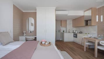 Una camera da letto moderna con un letto, un comodino e una piccola zona salotto con un tavolo e sedie.