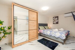 A bedroom with a bed, a wardrobe with a mirror, a potted plant, and a wall-mounted air conditioner. - Villa Zvonimir Zadarvillas (Promina)