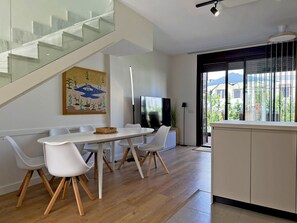 Una cocina moderna con comedor, una escalera y vistas al exterior.