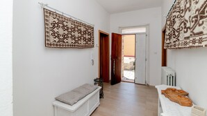 Ein Flur mit einem gemusterten Teppich, einer Bank und einem Holztisch mit Tablett.
