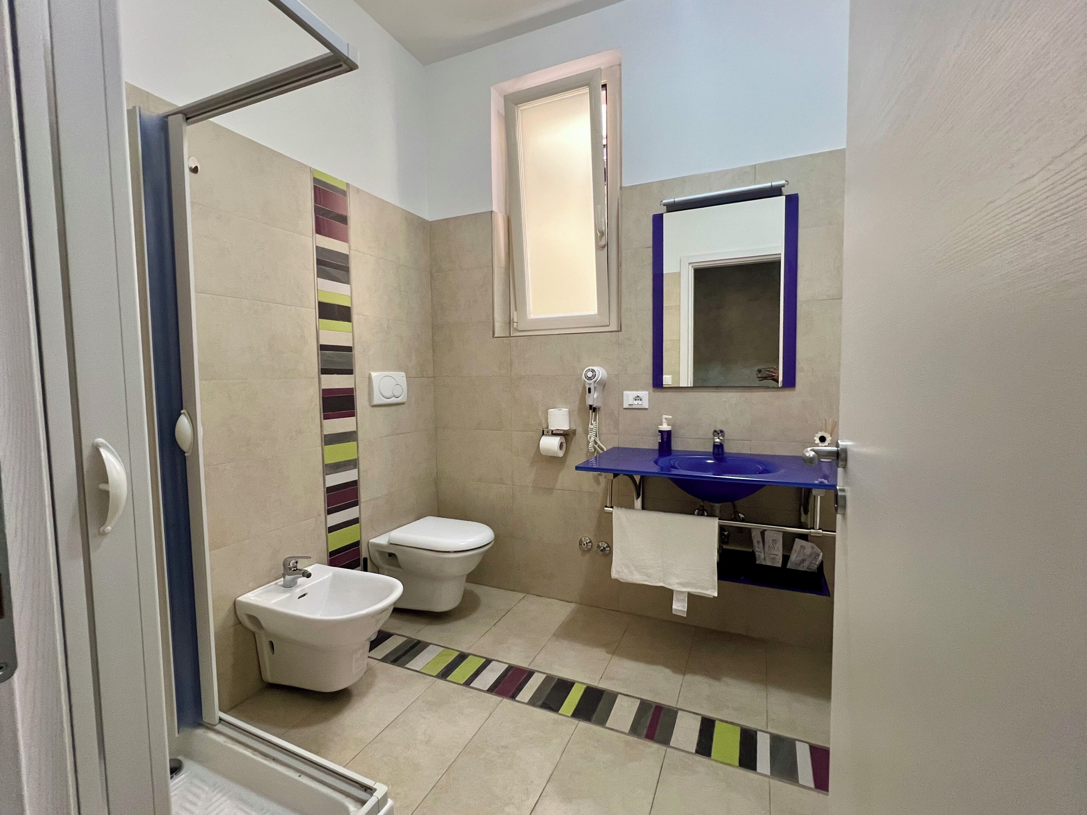 Tweepersoonskamer | Badkamer | Een haardroger, handdoeken, zeep, shampoo